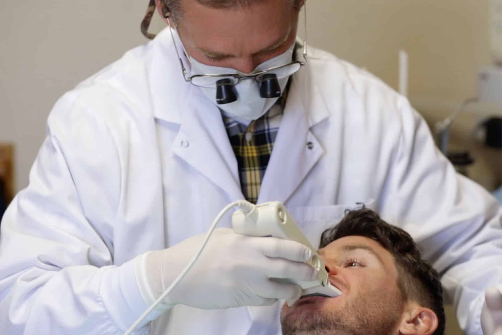 MFD Dentist Pointing at X-Ray Picture During Client Consultation